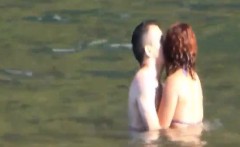 Horny couple having some fun in the water at the beach